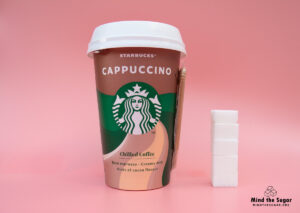 A photo of Starbucks Cappuccino cup with 4.7 cubes of sugar.