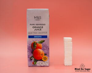 A photo of a 250 ml carton of M&S Pure Squeezed Smooth Orange Juice with 5.8 cubes of sugar.