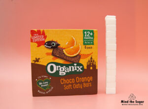 A photo of Organix Limited Edition Choco Orange Soft Oat Bar with 12 cubes of sugar.